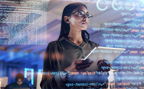 A woman looking at a board full of coding text.