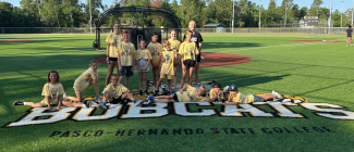 Young students posing on a softball field 