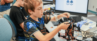 Young boy putting together a robot